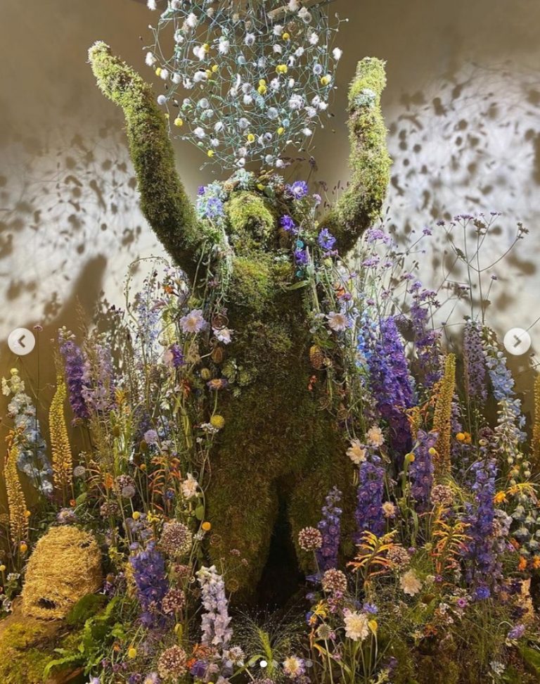 Kneeling Moss Figure as part of a floral display